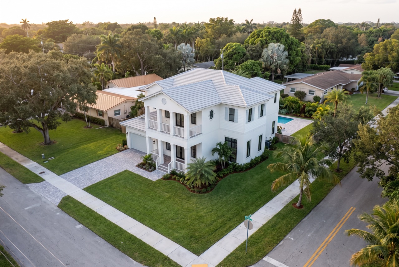 Concept rendering: drone view of a white two-story home with porches on the corner lot