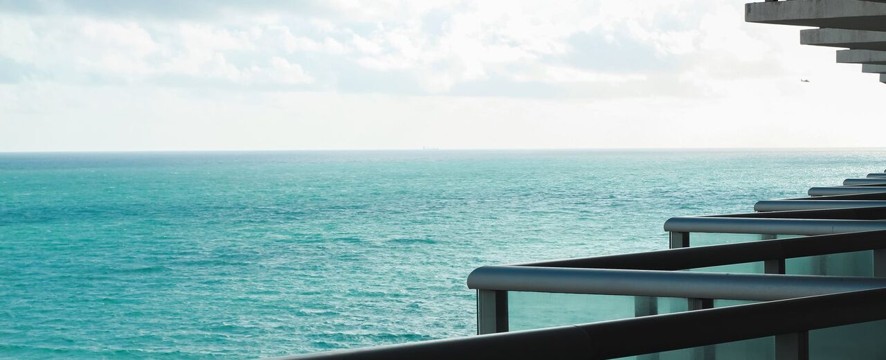 Oceanfront apartment balcony overlooking turquoise water, the kind of Miami rental international renters look for